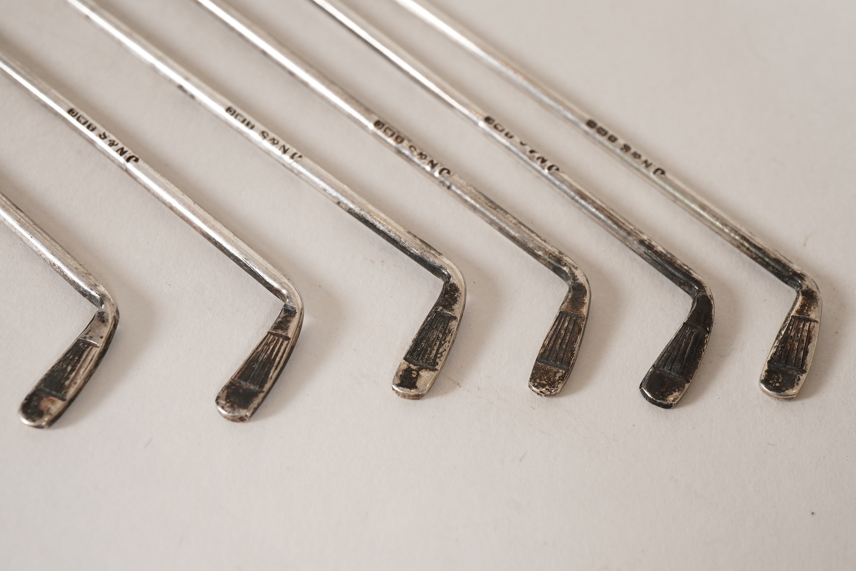A set of six George V novelty silver cocktail sticks with holder, modelled as a golf bag with clubs, by John Nowill & Sons